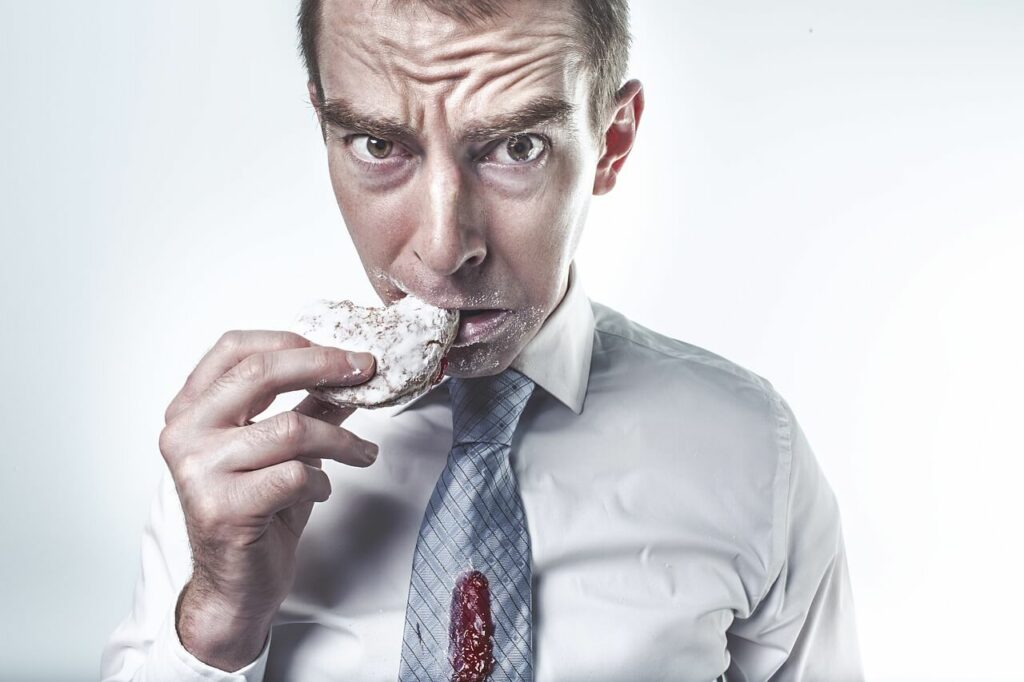image d'un homme qui mange une galette de riz. son visage montre de l'anxiété. Une manière d'illustrer la difficulté à trouver la bonne méthode pour perdre du poids. L'hypnose et le coaching peuvent vous aider